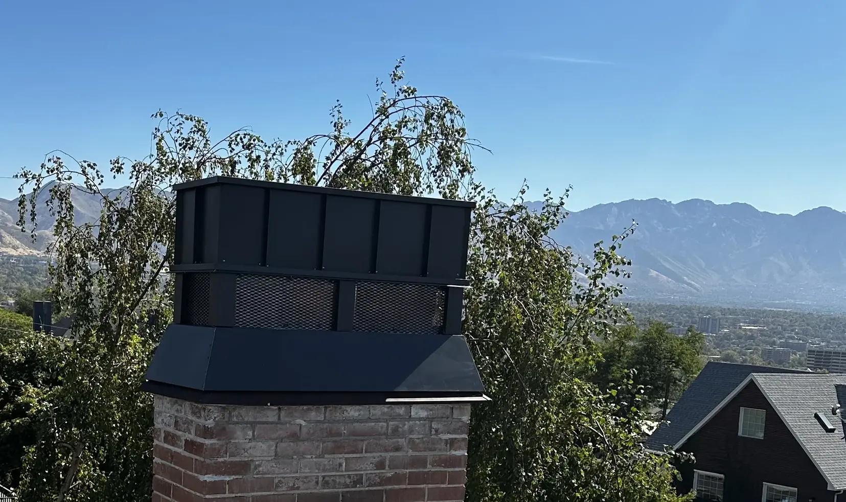 A custom bronze chimney cap installed on a home.